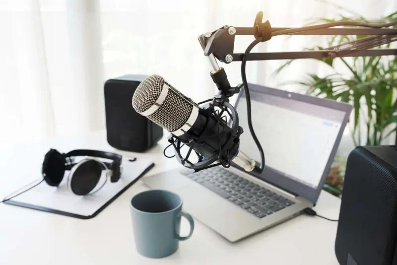 Podcastak grabatzeko mahaia mikrofono eta entzungailuekin