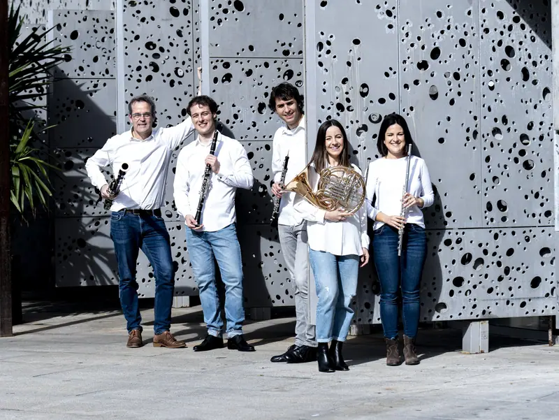 Le quintette devant la façade perforée du bâtiment moderne du musée