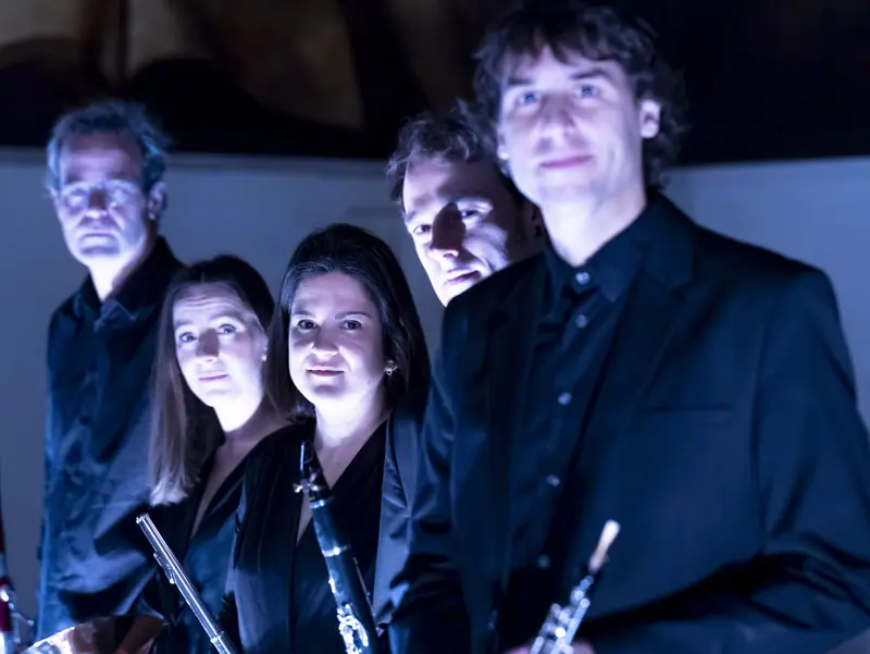 Les cinq musiciens en lumière bleue, dans une photo de nuit