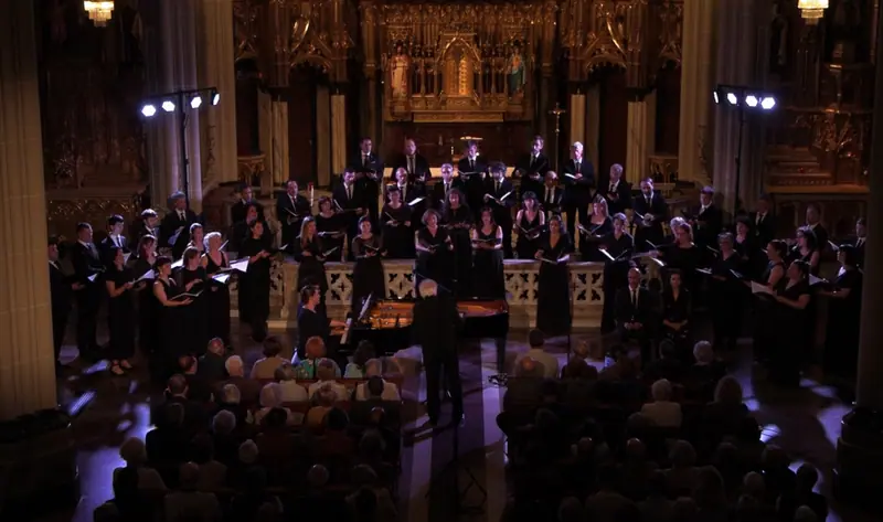 KUP Taldearen ikuspegi orokorra Brahmsen Requiem alemana kantatzen, urdinez argiztatutako eliza batean