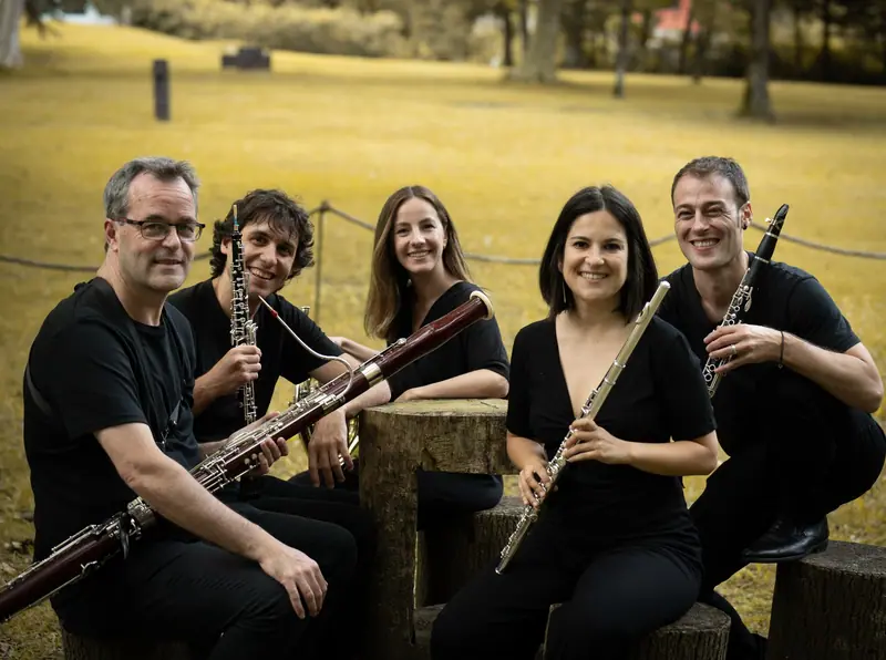 Les cinq musiciens de Sugaar Ensemble souriant avec leurs instruments dans les jardins de Chillida Leku