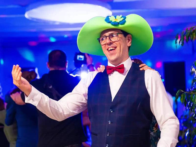 Jon con un sombrero verde gigante en plena fiesta