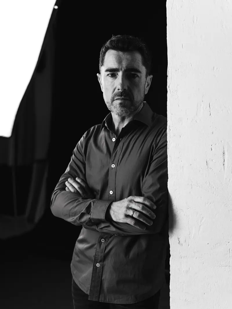 Esteban Urzelai en blanco y negro, apoyado en el marco de una puerta