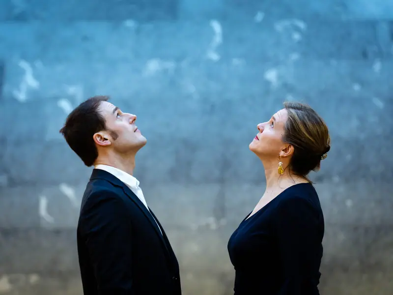 Eneko Iriarte et Amaia Zipitria regardant vers le haut devant un mur bleu
