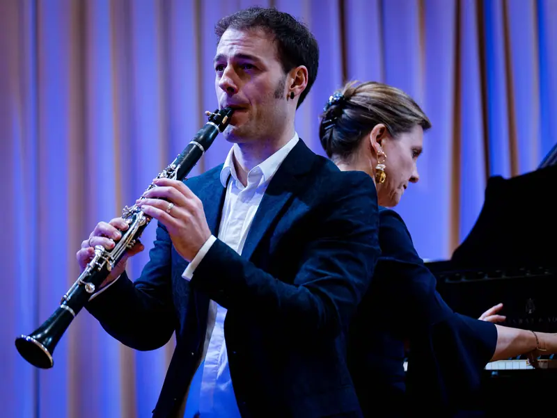 Eneko Iriarte klarinetean eta Amaia Zipitria pianoan, oihala urdinez argiztatuta