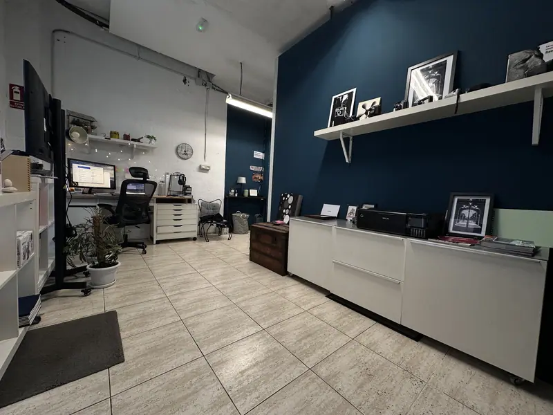 Intérieur de la boutique et du studio d’aiVídeo à Hondarribia, avec le mur bleu et des photos encadrées
